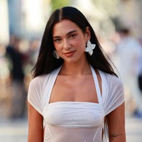 Dua Lipa menyempurnakan penampilannya yang serba putih dengan anting-anting ukuran besar yang berbeda bentuk. Pada telinga kanan dia memakai anting bintang, telinga kiri anting lingkaran ukuran besar. Foto: Dok. Arnold Jerocki/Getty Images
