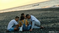 Masyarakat pun bisa duduk-duduk di atas pasir sambil menikmati deburan ombak yang tak terlalu besar.