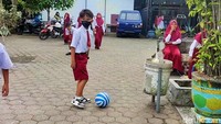 Hampir 2 minggu berpisah, membuat Farel rindu bermain dengan teman sekolah. Saat istirahat jam pelajaran, ia bermain bola di halaman sekolah. Foto: Ardian Fanani/detikJatim