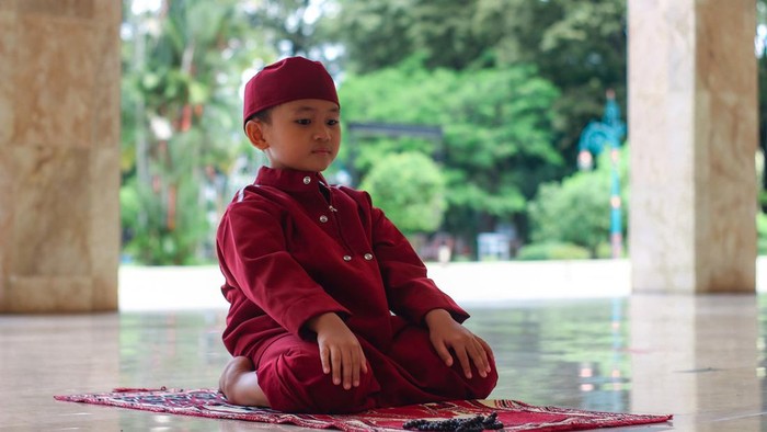 Asian Muslim boy at mosque praying