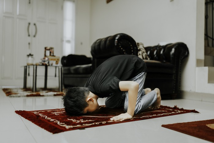 asian muslim kid is salah (doa) in home