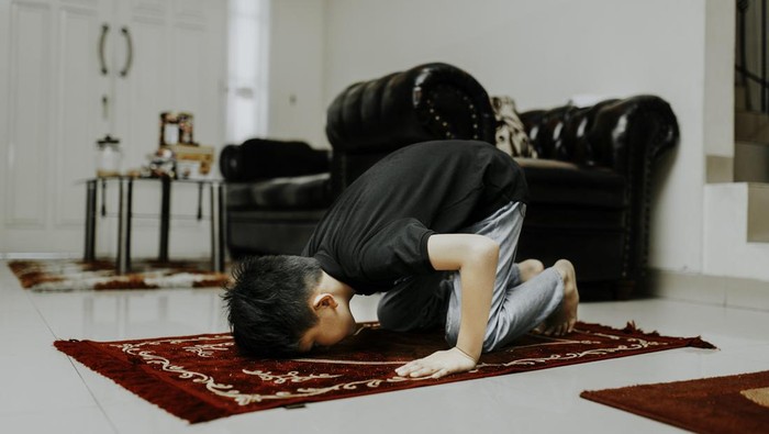 asian muslim kid is salah (doa) in home