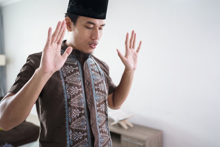 Young asian Muslim man praying at home. takbir before start the prayer