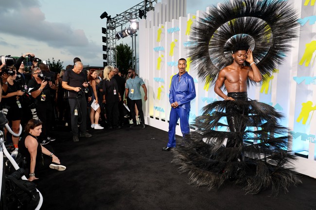 Lil Nas X kembali mendobrak aturan berbusana sesuai gender dengan rancangan Harris Reed. Rok bulu hitam berstruktur dipadu headpiece dramatis menjadi andalannya. (Foto: Getty Images/Dia Dipasupil)