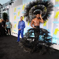 Lil Nas X kembali mendobrak aturan berbusana sesuai gender dengan rancangan Harris Reed. Rok bulu hitam berstruktur dipadu headpiece dramatis menjadi andalannya. (Foto: Getty Images/Dia Dipasupil)