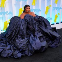 Lizzo sebenarnya bukan tipikal wanita yang takut memamerkan bentuk tubuhnya. Namun di karpet hitam MTV VMA 2022, ia tetap sukses tampil memukau dengan menghadirkan drama dalam balutan gaun megar biru gelap dari Jean Paul Gaultier yang dirancang oleh Glenn Martens. Lipstik dan sarung tangan senada, serta padanan anting statement dan rambut wet-look, kian menyempurnakan gaya pelantun About Damn Time itu. Foto: WireImage/Gotham