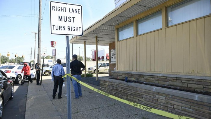 Detroit Police and investigators look over a homicide scene on Wyoming Avenue, near the corner of Seven Mile Road, Sunday, Aug. 28, 2022, in Detroit. Four people were shot, with fatalities, by a person who appeared to be firing at people randomly over a roughly 2 1/2-hour period Sunday morning in Detroit, police said. (Jose Juarez/Special to Detroit News via AP)