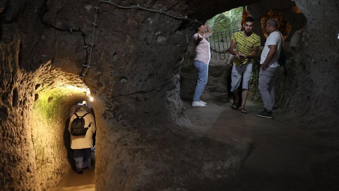 Tourists explore a passage in the Derinkuyu underground city, in Turkey's central Nevsehir province, on August 24, 2022. - The ancient city of Elengubu, known today as Derinkuyu, reaches the depth of 85m below the Earth's surface, and could accommodate up to 20,000 people. (Photo by OMAR HAJ KADOUR / AFP) (Photo by OMAR HAJ KADOUR/AFP via Getty Images)