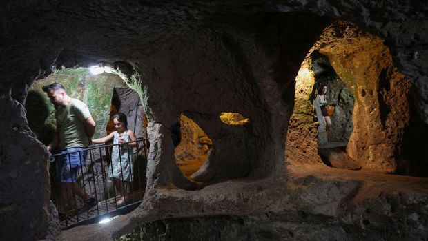 Tourists explore a passage in the Derinkuyu underground city, in Turkey's central Nevsehir province, on August 24, 2022. - The ancient city of Elengubu, known today as Derinkuyu, reaches the depth of 85m below the Earth's surface, and could accommodate up to 20,000 people. (Photo by OMAR HAJ KADOUR / AFP) (Photo by OMAR HAJ KADOUR/AFP via Getty Images)