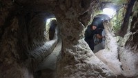 Seorang turis berjalan melalui lorong di kota bawah tanah Derinkuyu, di provinsi Nevsehir tengah Turki, Rabu, (24/8/2022).