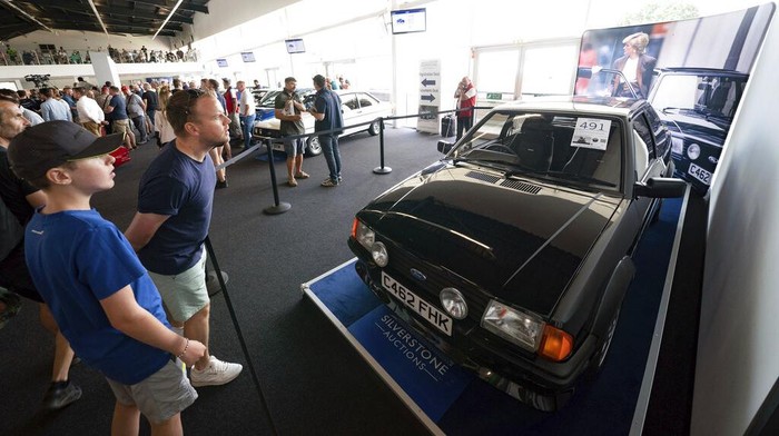 Mobil Ford Escort Langka Milik Putri Diana Dilelang, Begini Wujudnya People view the Ford Escort RS Turbo Series 1, previously owned by Diana, Princess of Wales, on display at the Silverstone Race Circuit near Towcester, Northamptonshire, England, before it goes under the hammer on Saturday at Silverstone Classics, Saturday Aug. 27, 2022. (Joe Giddens/PA via AP)