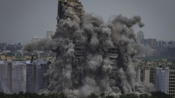 Cloud of dust rises as twin high-rise apartment towers are razed to ground in Noida, outskirts of New Delhi, India, Sunday, Aug. 28, 2022. The demolition was done after the country's top court declared them illegal for violating building norms. The 32-story and 29-story towers, constructed by a private builder were yet to be occupied and became India's tallest structures to be razed to the ground. (AP Photo/Altaf Qadri)