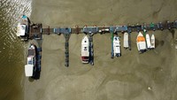 Perahu tergeletak di dasar sungai kering Danube di kota Novi Sad, Serbia, Selasa, (16/8/2022). Ketinggian air Sungai Danube turun satu setengah meter dalam tiga pekan terakhir. Prakiraan cuaca juga menyebut hujan belum akan turun dalam waktu dekat. (Fedja Grulovic/Reuters)