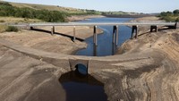 Penampakan jembatan kuno yang terpapar oleh permukaan air rendah di Waduk Baitings di Yorkshire saat suhu tertinggi terlihat di Inggris, Ripponden, Inggris, Jumat, (12/8/2022). Ketinggian air rendah di waduk telah mengungkapkan sisa-sisa jalan kuno yang terendam banjir untuk membangun waduk pada 1950-an. (AP/Jon Super)