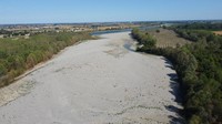 Dasar sungai kering dari sungai Po di Sermide, Italia, Kamis, (11/8/2022). Sungai Po mengalir sejauh 652 kilometer (405 mil) dari barat laut kota Turin ke Venesia. Tapi Italia Utara tidak melihat curah hujan selama berbulan-bulan. Suhu yang lebih tinggi dari biasanya membuat sisanya, meninggalkan cekungan Po tanpa reservoir air musim panasnya, dengan dampak pada ekonomi, pariwisata, dan pertanian di sekitarnya. (AP/Luigi Navarra)