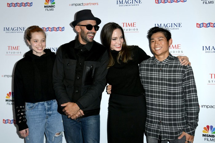 LOS ANGELES, CALIFORNIA - NOVEMBER 18: (L-R) Shiloh Jolie-Pitt, street artist JR, actress Angelina Jolie and Pax Thien Jolie-Pitt attend the Los Angeles premiere of MSNBC Films 