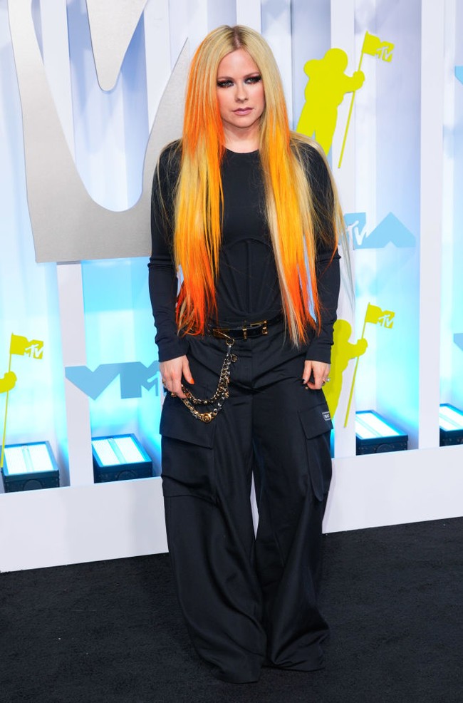 Penyanyi 37 tahun itu hadir di MTV Video Music Awards 2022 dengan pakaian serba hitam. Avril mengenakan kaus lengan panjang hitam, celana pipa warna senada dengan kausnya dan aksesori rantai di pinggangnya.  Foto: Getty Images