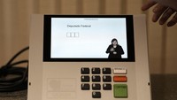 Mesin e-voting dengan layar kecil dengan nomor dan video petunjuk khusus. Dalam foto ini, terdapat tulisan dalam bahasa Portugis yang berarti Anggota Kongres Federal.