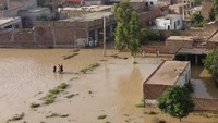 Warga berjalan di tengah banjir yang melanda kawasan Pakistan ini. Sebelumnya Pemerintah Pakistan telah mengumumkan keadaan darurat untuk menangani banjir musim hujan ini. Para pejabat setempat mengatakan banjir tahun ini sebanding dengan banjir tahun 2010, yang tercatat sebagai yang terburuk ketika sedikitnya 2.000 orang tewas dan nyaris seperlima wilayah Pakistan terendam banjir. (Abdul Majeed/AFP/Getty Images)