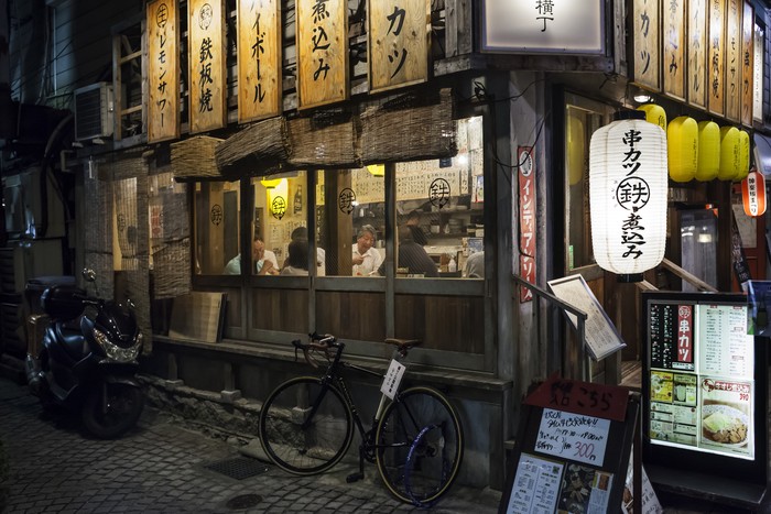 Horizontal exterior view of a cozy and popular restaurant full of customers in Kagurazaka, Tokyo