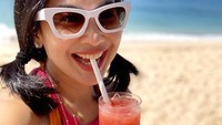 Menikmati segelas jus di pinggir pantai, Feni Rose terlihat awet muda ya? Muda terosss, komentar Aming dalam foto ini.