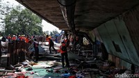 Petugas merobohkan bangunan semi permanen di kawasan ini. Awalnya lokasi ini adalah rel kereta api, tetapi semenjak banyak bangunan liar kawasan ini ditutup.