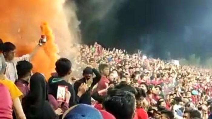 Penonton menyalakan smoke bomb saat pertandingan PSM vs Persib di Stadion Gelora BJ Habibie