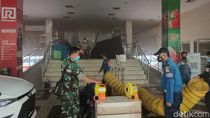Petugas menyedot asap akibat kebakaran di Mal Serang