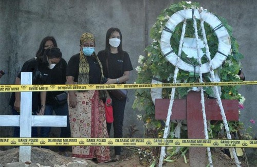 Rosti Simanjuntak (tengah), ibu almarhum Brigadir Yoshua di makam anaknya
