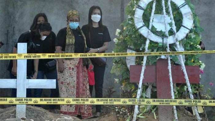 Rosti Simanjuntak (tengah), ibu almarhum Brigadir Yoshua di makam anaknya