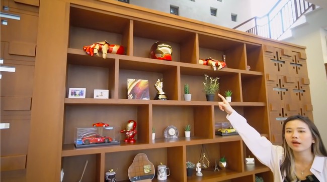 Rak buku di ruang keluarga dihiasi berbagai memorabilia bertema Marvel, khususnya Iron Man. (Foto: YouTube/Jessica Jane)