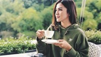 Ditemani pemandangan alam yang rimbun dan sejuk. Dirinya berpose cantik saat minum kopi dengan semilir angin yang sejuk. Foto: Instagram @fakhranaaa