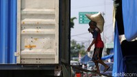 Pekerja meniti papan kayu untuk memindahkan karung beras. Perum Bulog mengatakan memiliki stok beras kurang lebih 1,1 juta ton. Stok tersebut sudah memenuhi ketentuan Organisasi Pangan dan Pertanian (FAO). 