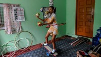 Han Myint Mo menendang bola logam berwarna emas, memutar dan menangkapnya dengan bilah pisau yang dipegang dengan mulutnya.
