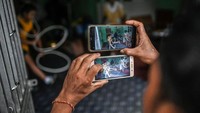Seseorang merekam aksi kakek dan cucu saat tengah berlatih juggling bola yang merupakan tradisi Myanmar. 