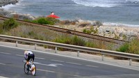 Pebalap tim Equipo Kern Pharma, Raúl García Pierna melahap etape ke-10 sejauh 30,9 km. Tampak di sisi kanan berupa lautan. Faktor angin menjadi penghambat kecepatan dalam etape ini. (Tim de Waele/Getty Images)
