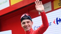 Remco Evenepoel melambaikan tangan ke arah penonton saat berdiri di podium kemenangan etape ke-10 La Vuelta a Espana 2022, di Kota Alicante, Spanyol, Selasa (30/8/2022). Sejauh ini, ia unggul 48 detik dari juara bertahan Primoz Roglic dalam klasemen sementara. (David Stockman/AFP/Getty Images)