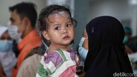 Seorang korban luka digendong orangtuanya. Menurut keterangan kepolisian, kecelakaan tersebut diakibatkan rem blong.
