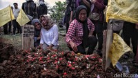 Ibunya almarhum Naufal Shidqi bin Budi Wahyudi menangis di pusara anaknya.