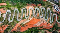 Terakhir, ada jalan berliku yang rumit di sebuah pegunungan di Kunming, Provinsi Yunnan, China. Jalan berkelok ini memiliki 68 tikungan tajam sepanjang 6,3 kilometer. Aerial ini diambil pada 12 Maret 2022.