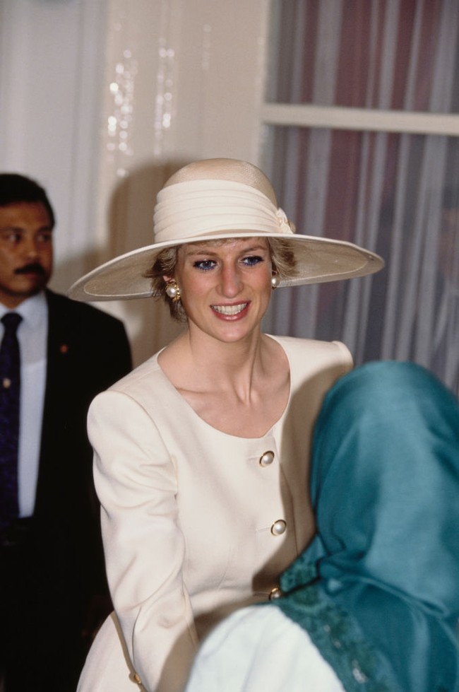 Busana hari pertama Putri Diana di Indonesia dilengkapi aksesori pendukung. Salah satunya anting mutiara yang senada dengan kancing blusnya. Tidak ketinggalan topi boater yang dipermanis dengan aksen bandana bermutiara nan elegan. (Foto: Getty Images/Princess Diana Archive)