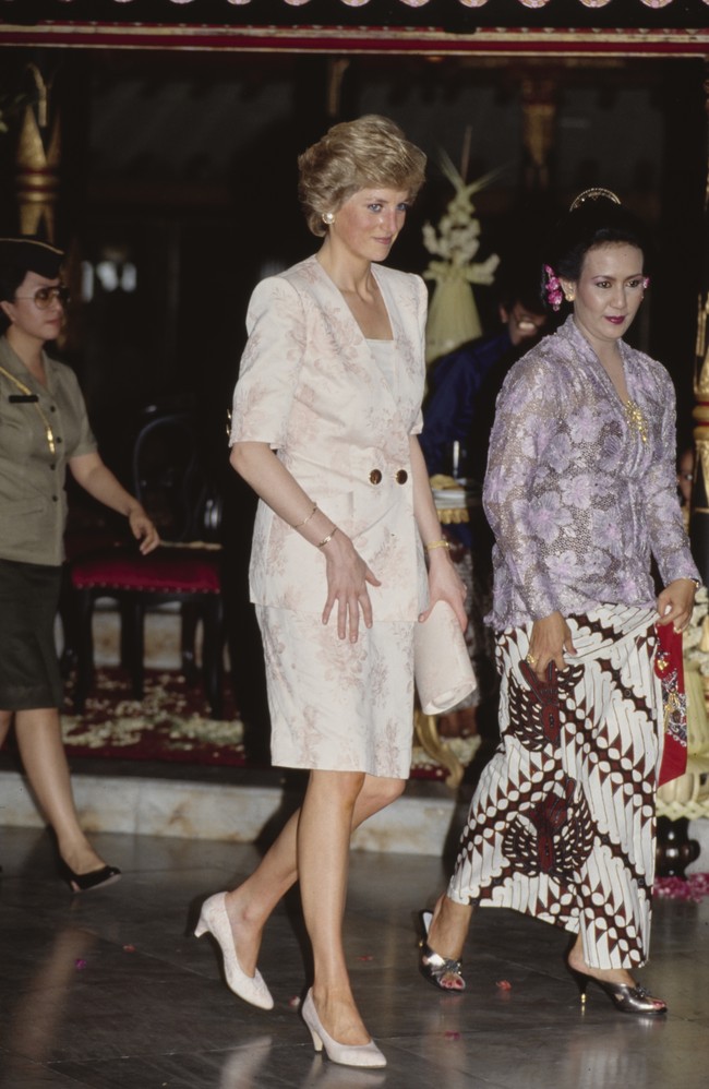 Tur di Indonesia juga mencakup kunjungan ke Yogyakarta. Bertemu keluarga Sultan Hamengkubuwana X, ia memakai setelan rok bermotif floral dan kitten heels, berikut clutch senada. (Foto: Getty Images/Tim Graham)