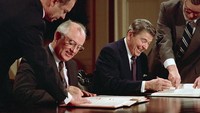 Presiden Amerika Serikat Ronald Reagan dan Mikhail Gorbachev menandatangani perjanjian pengendalian senjata yang melarang penggunaan rudal nuklir jarak menengah di Washington DC, Amerika Serikat, Selasa (8/12/1987). (Bettmann/Getty Images)  