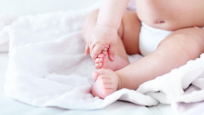 Cropped image of a baby girl holding her own foothttp://195.154.178.81/DATA/istock_collage/0/shoots/781120.jpg