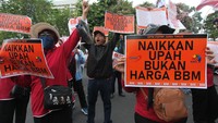 Buruh membentangkan poster saat berunjuk rasa di Jalan Gubernur Suryo, Surabaya, Jawa Timur, Rabu (31/8/2022).