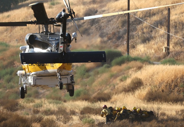 1419795099 CASTAIC, CALIFORNIA - AUGUST 31: A helicopter departs after dropping off firefighters as the Route Fire burns nearby on August 31, 2022 near Castaic, California. Evacuations have been ordered as the brush fire has scorched more than 4,600 acres and closed down the 5 freeway at the start of a brutal heat wave in Southern California. The National Weather Service issued an Excessive Heat Warning for most of Southern California through Labor Day. Climate models almost unanimously predict that heat waves will become more intense and frequent as the planet continues to warm. (Photo by Mario Tama/Getty Images)