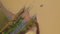 Sebuah mobil terlihat sebagian terendam air banjir, di Bardney, dekat Lincoln, Inggris, Jumat (15/11/2019). (Getty Images/Christopher Furlong)  