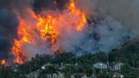 Api membakar ribuan hektar lahan di belakang permukiman warga di Chino Hills, California, Amerika Serikat, Selasa (27/10/2020). (Getty Images/David McNew)  