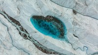 Lanskap ini memperlihatkan sebuah danau di Greenland yang bentuknya menyerupai hati. Foto drone ini dijepret pada 16 Agutsus 2022.