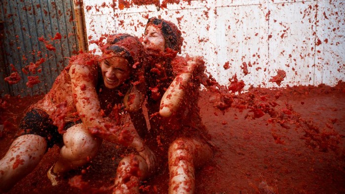 Revelers play in tomato pulp during the annual 